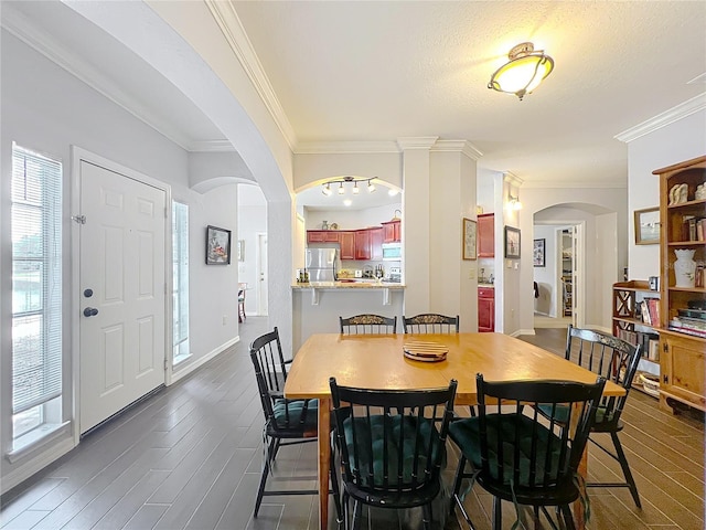 dining room featuring crown molding, dark wood finished floors, and plenty of natural light