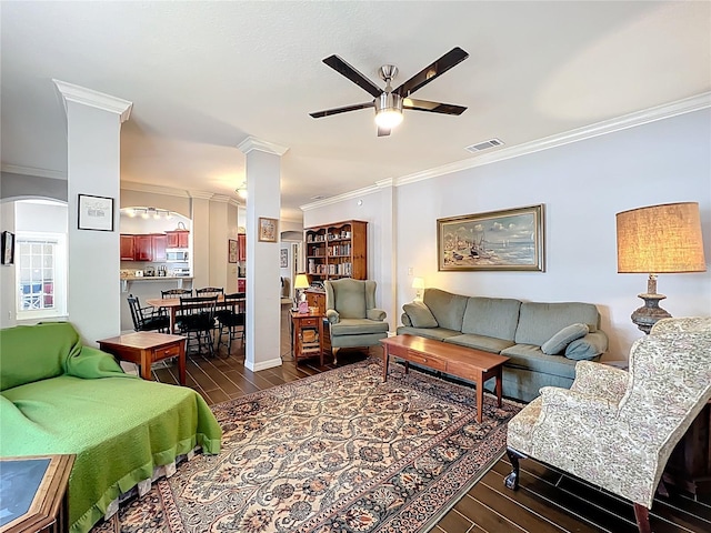 living room featuring a ceiling fan, visible vents, arched walkways, wood finished floors, and ornamental molding