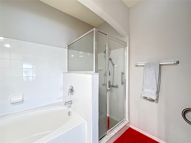 full bath featuring baseboards, a garden tub, and a stall shower
