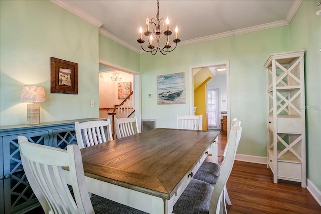 dining area featuring an inviting chandelier, wood finished floors, visible vents, baseboards, and ornamental molding