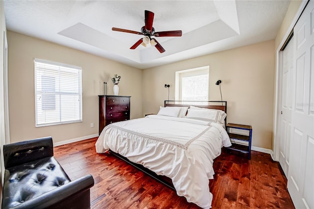7348 Yoder St, Windermere, FL 34786 - bedroom featuring a closet, baseboards, wood finished floors, and a tray ceiling