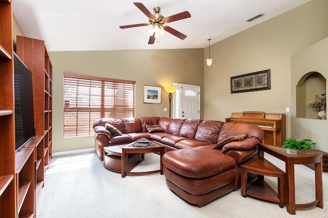 living area featuring a ceiling fan, a textured ceiling, visible vents, vaulted ceiling, and light carpet