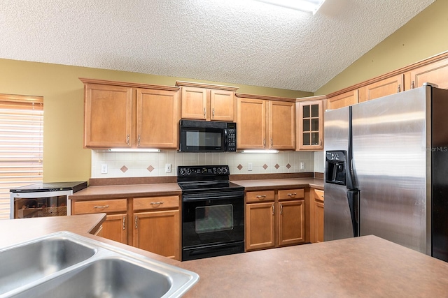 kitchen with glass insert cabinets, tasteful backsplash, black appliances, and a textured ceiling