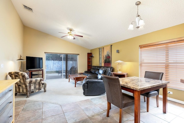 dining space with a ceiling fan, light colored carpet, visible vents, and lofted ceiling