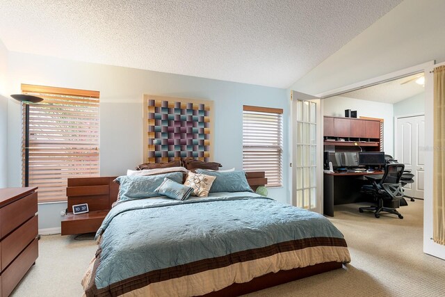bedroom with lofted ceiling, a textured ceiling, and light colored carpet