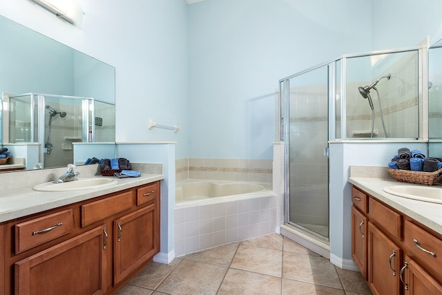 bathroom with a garden tub, tile patterned floors, two vanities, a sink, and a stall shower