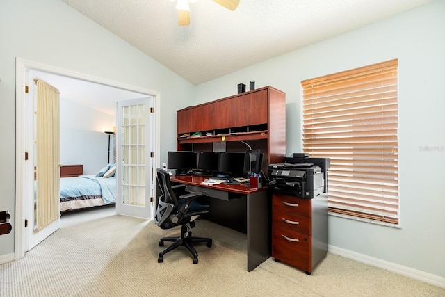 home office with light carpet, a textured ceiling, a ceiling fan, baseboards, and vaulted ceiling