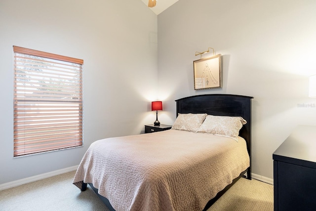 bedroom with carpet floors, baseboards, and lofted ceiling