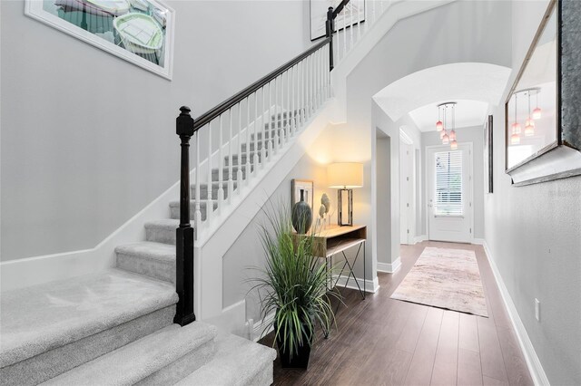 8263 Bellow St, Orlando, FL 32827 - foyer with baseboards, arched walkways, wood finished floors, and stairway