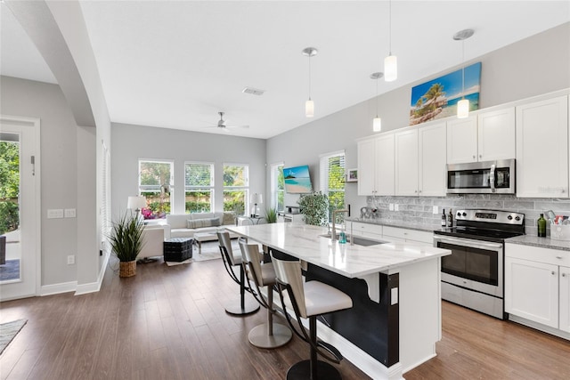 8263 Bellow St, Orlando, FL 32827 - kitchen with decorative backsplash, ceiling fan, a sink, light stone counters, and stainless steel appliances
