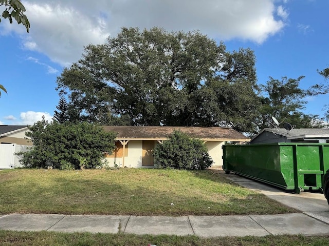 view of front of house featuring fence, a front yard, and stucco siding