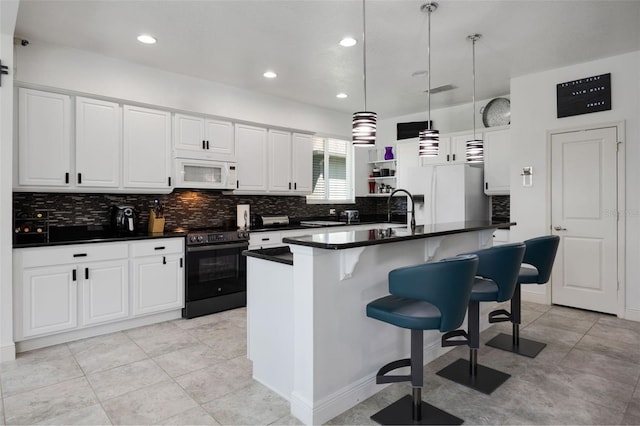 kitchen with white appliances, white cabinetry, dark countertops, and decorative backsplash