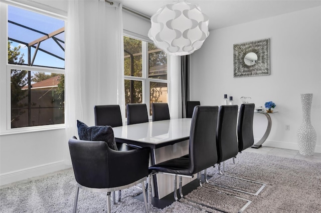 dining space with baseboards, tile patterned floors, and a notable chandelier
