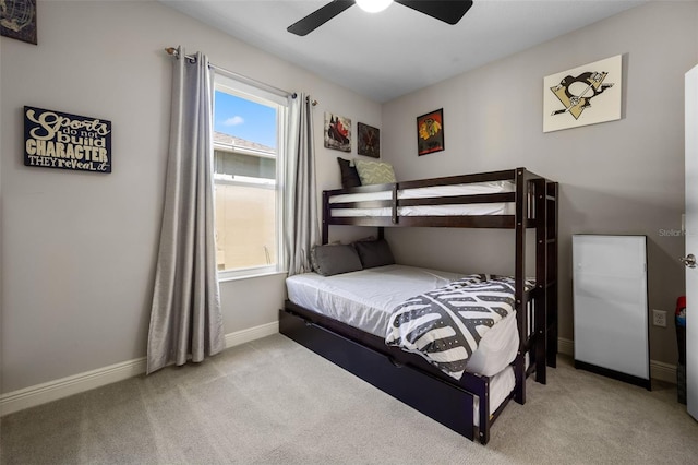 carpeted bedroom featuring baseboards and a ceiling fan
