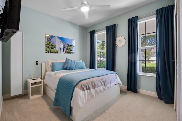 bedroom with baseboards, light carpet, and multiple windows