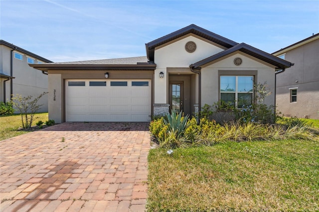3128 Oxbow Ct, Harmony, FL 34773 - ranch-style house featuring decorative driveway, an attached garage, a front yard, and stucco siding