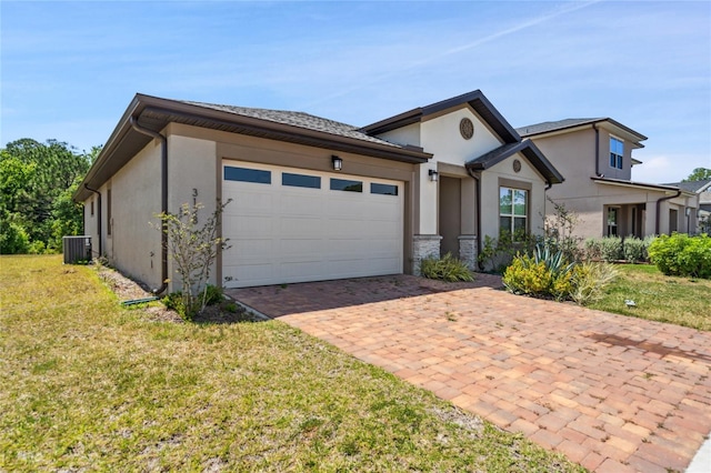3128 Oxbow Ct, Harmony, FL 34773 - view of front of house with a garage, a front lawn, central AC, and stucco siding