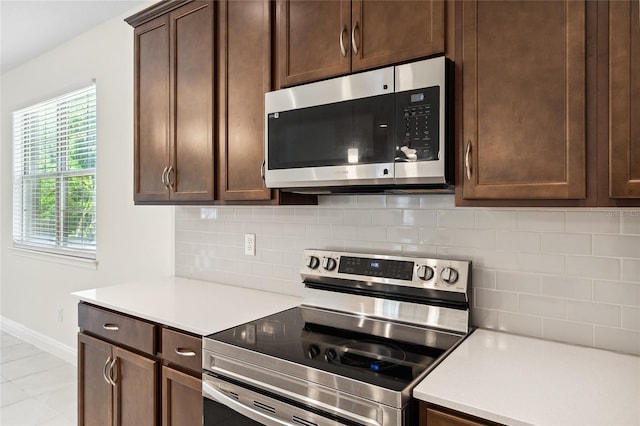 3128 Oxbow Ct, Harmony, FL 34773 - kitchen featuring dark brown cabinets, light countertops, stainless steel appliances, baseboards, and tasteful backsplash