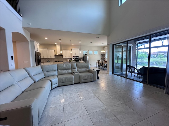 living area featuring recessed lighting, arched walkways, and a high ceiling