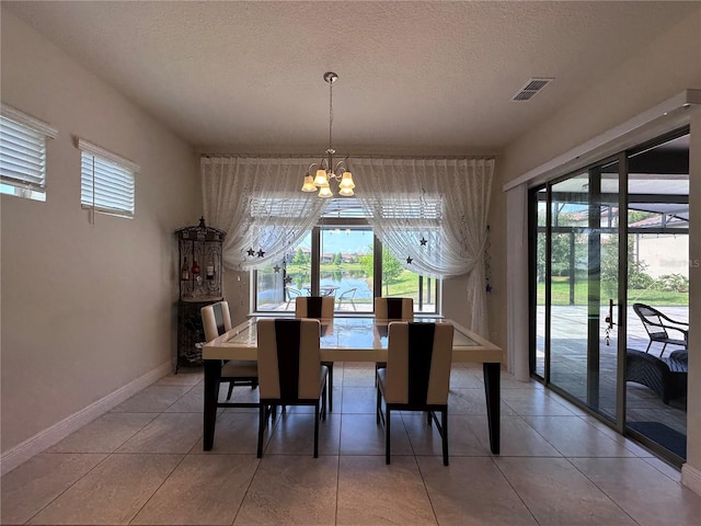 dining room with plenty of natural light, a notable chandelier, a textured ceiling, and visible vents