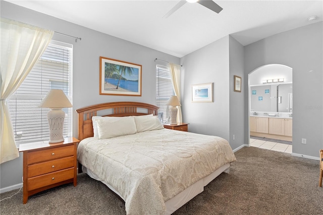 bedroom with baseboards, carpet, ensuite bathroom, and ceiling fan