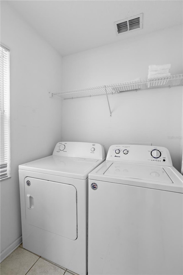 laundry room featuring light tile patterned flooring, laundry area, visible vents, and washer and clothes dryer