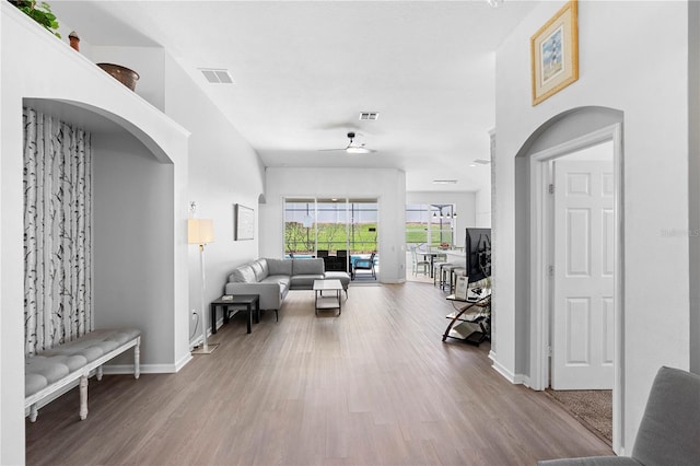 interior space featuring baseboards, ceiling fan, wood finished floors, and visible vents