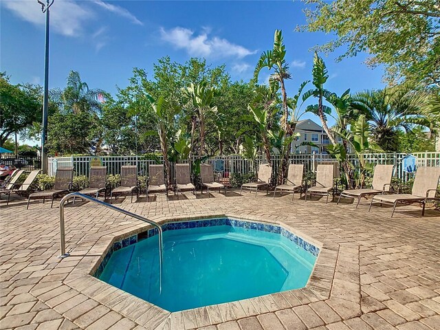 view of swimming pool featuring a patio and fence