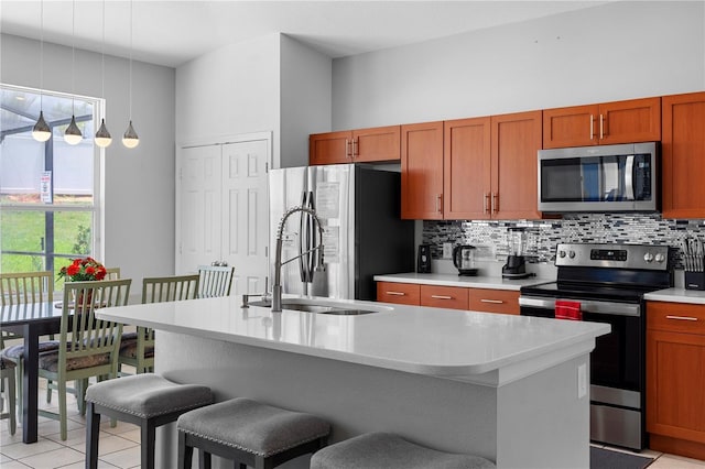 2263 Wyndham Palms Way, Kissimmee, FL 34747 - kitchen with stainless steel appliances, decorative backsplash, light countertops, light tile patterned floors, and a breakfast bar