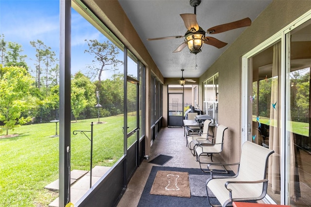 sunroom / solarium featuring plenty of natural light and a ceiling fan