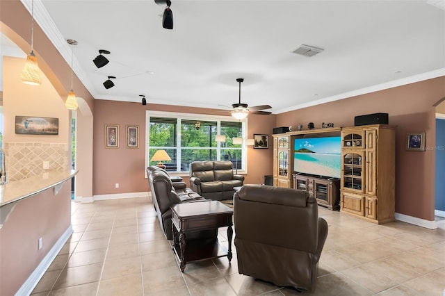 living room featuring visible vents, arched walkways, crown molding, and light tile patterned floors
