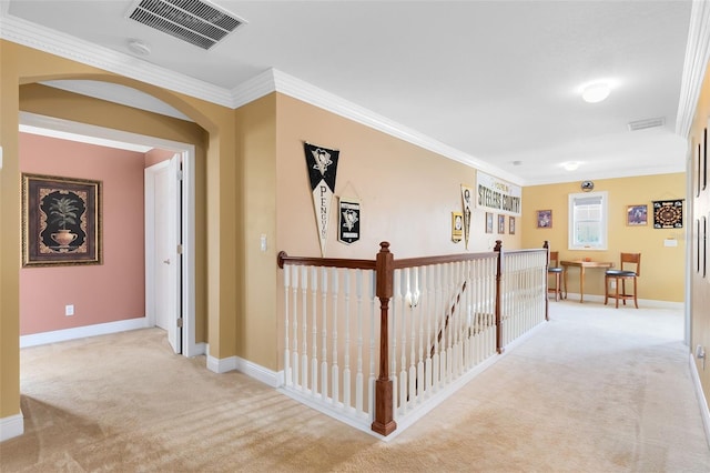hallway featuring visible vents, arched walkways, light carpet, and ornamental molding