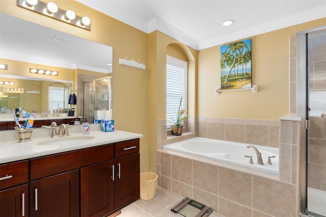 bathroom featuring a healthy amount of sunlight, a garden tub, tile patterned flooring, a stall shower, and vanity