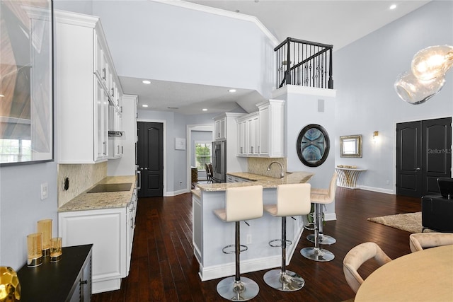 1840 Bryan Ave, Winter Park, FL 32789 - kitchen featuring stainless steel fridge, white cabinetry, baseboards, a peninsula, and backsplash