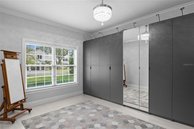 1840 Bryan Ave, Winter Park, FL 32789 - unfurnished bedroom featuring crown molding, baseboards, a notable chandelier, and wood finished floors