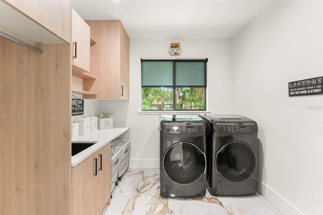 washroom with baseboards, independent washer and dryer, cabinet space, and marble finish floor