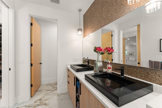 kitchen with visible vents, marble finish floor, baseboards, a sink, and hanging light fixtures