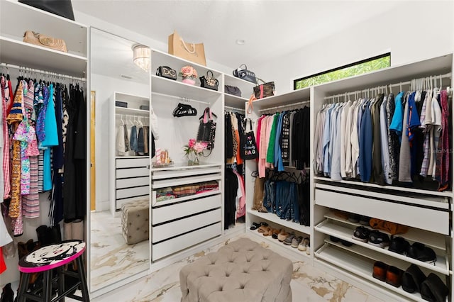 walk in closet with marble finish floor