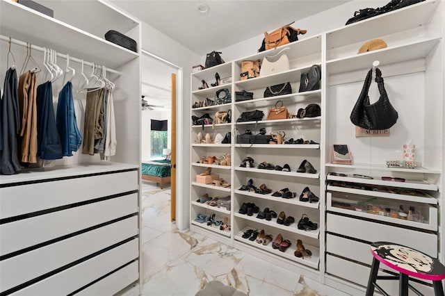 spacious closet with ceiling fan and marble finish floor