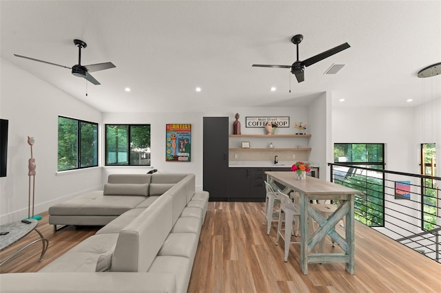 living room featuring ceiling fan, a wealth of natural light, and light wood finished floors