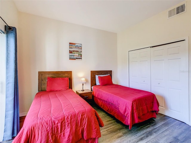bedroom with a closet, visible vents, and wood finished floors