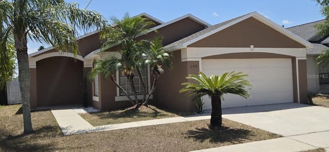 view of front of house with a garage, stucco siding, and driveway