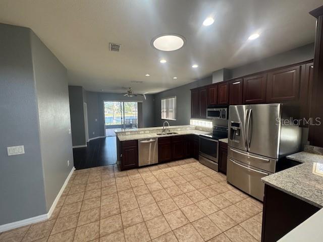 10414 Andover Point Cir, Orlando, FL 32825 - kitchen featuring visible vents, dark brown cabinetry, ceiling fan, a sink, and appliances with stainless steel finishes