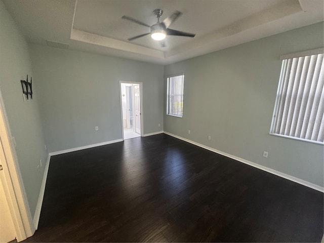 10414 Andover Point Cir, Orlando, FL 32825 - empty room with a raised ceiling, baseboards, a ceiling fan, and dark wood finished floors