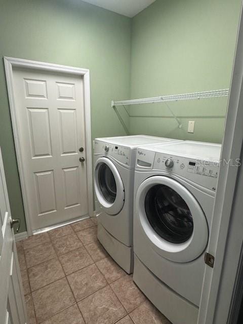 10414 Andover Point Cir, Orlando, FL 32825 - laundry area with light tile patterned flooring, laundry area, and washing machine and dryer