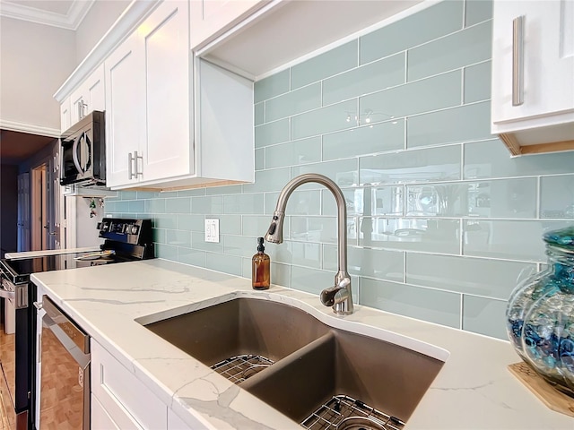1072 SE 155th St, Summerfield, FL 34491 - kitchen featuring white cabinets, appliances with stainless steel finishes, a sink, tasteful backsplash, and ornamental molding