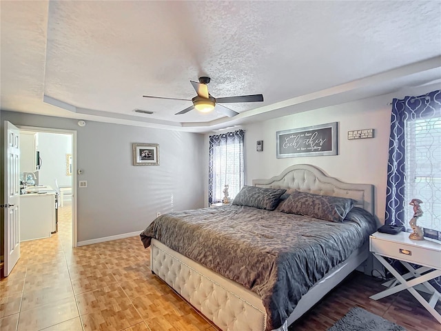 1072 SE 155th St, Summerfield, FL 34491 - bedroom with visible vents, a textured ceiling, a raised ceiling, and baseboards