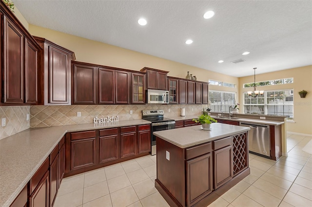 kitchen with decorative backsplash, a sink, an inviting chandelier, stainless steel appliances, and recessed lighting
