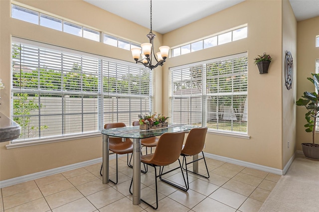 dining room featuring a healthy amount of sunlight, baseboards, light tile patterned floors, and a notable chandelier