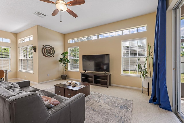 living area with visible vents, a ceiling fan, baseboards, and carpet floors